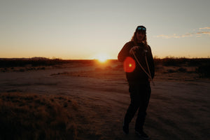 Person walking through desert at sunset