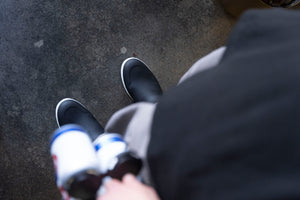 POV perspective of someone holding beer while wearing The DRY Brand Boots