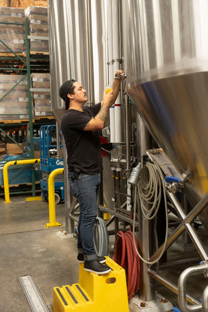 Man on step stool getting beer at brewery
